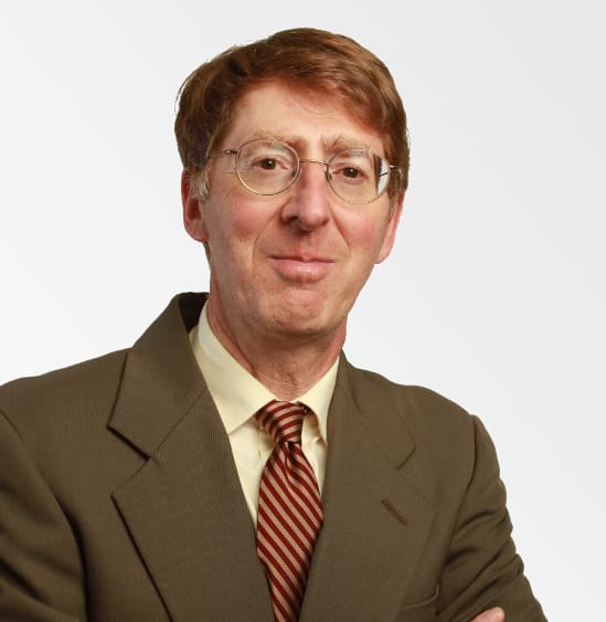 A man in a suit and tie with glasses.
