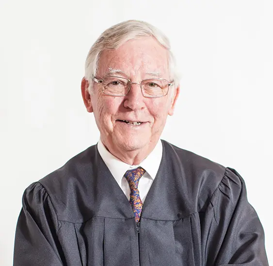 A man in an official robe and glasses.